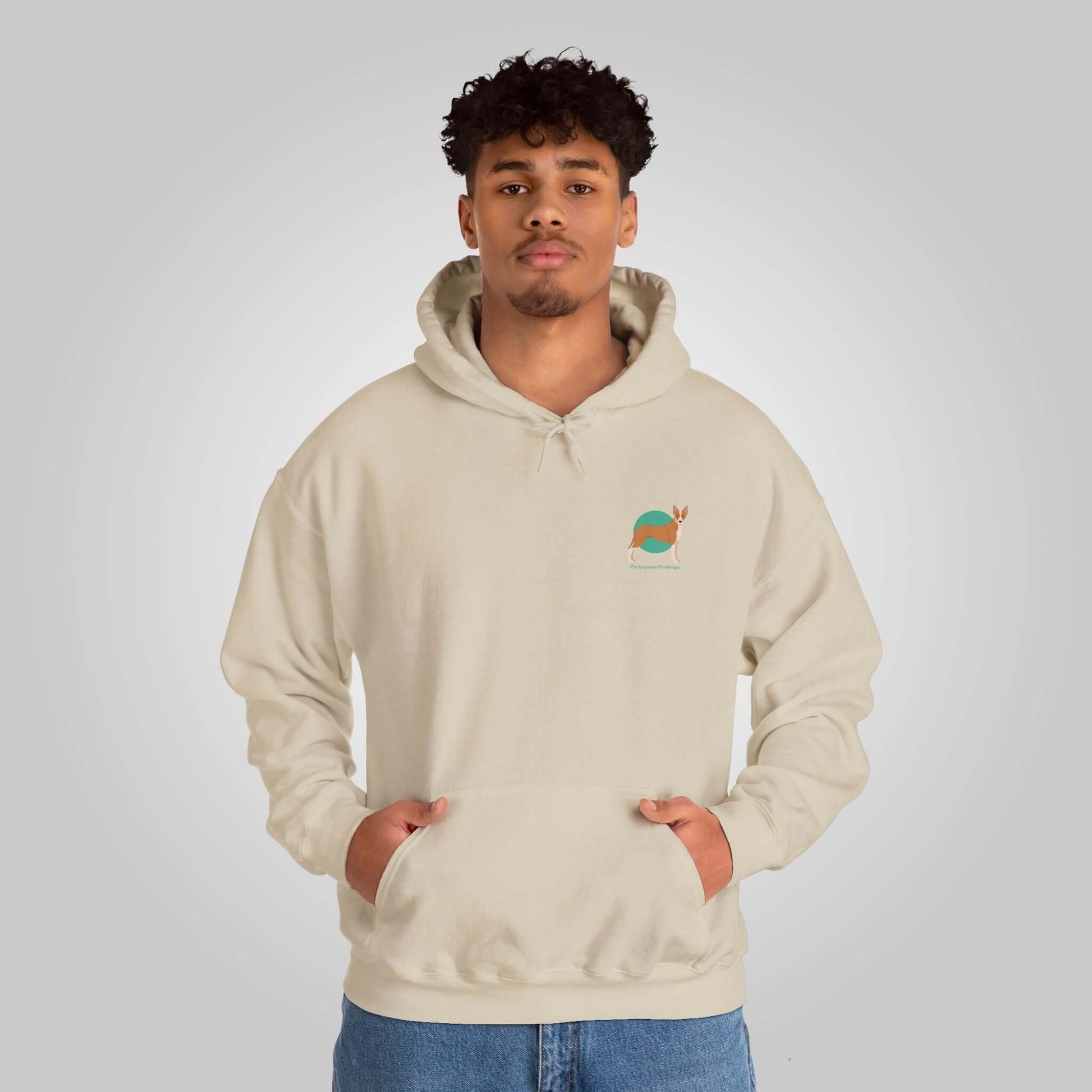 Young man wearing a beige Portuguese Podengo hooded sweatshirt with a small colorful dog logo