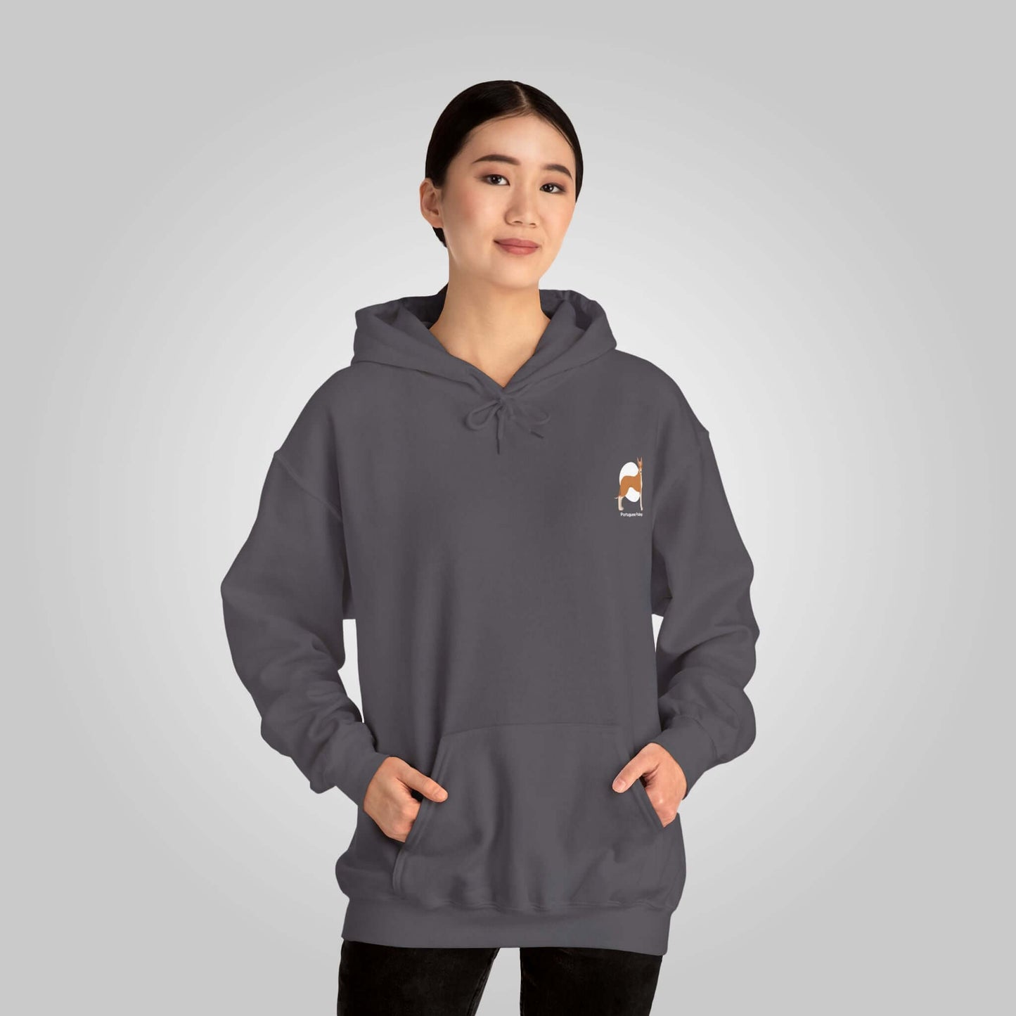 Woman wearing a Portuguese Podengo dog graphic hoodie, standing against a light grey background