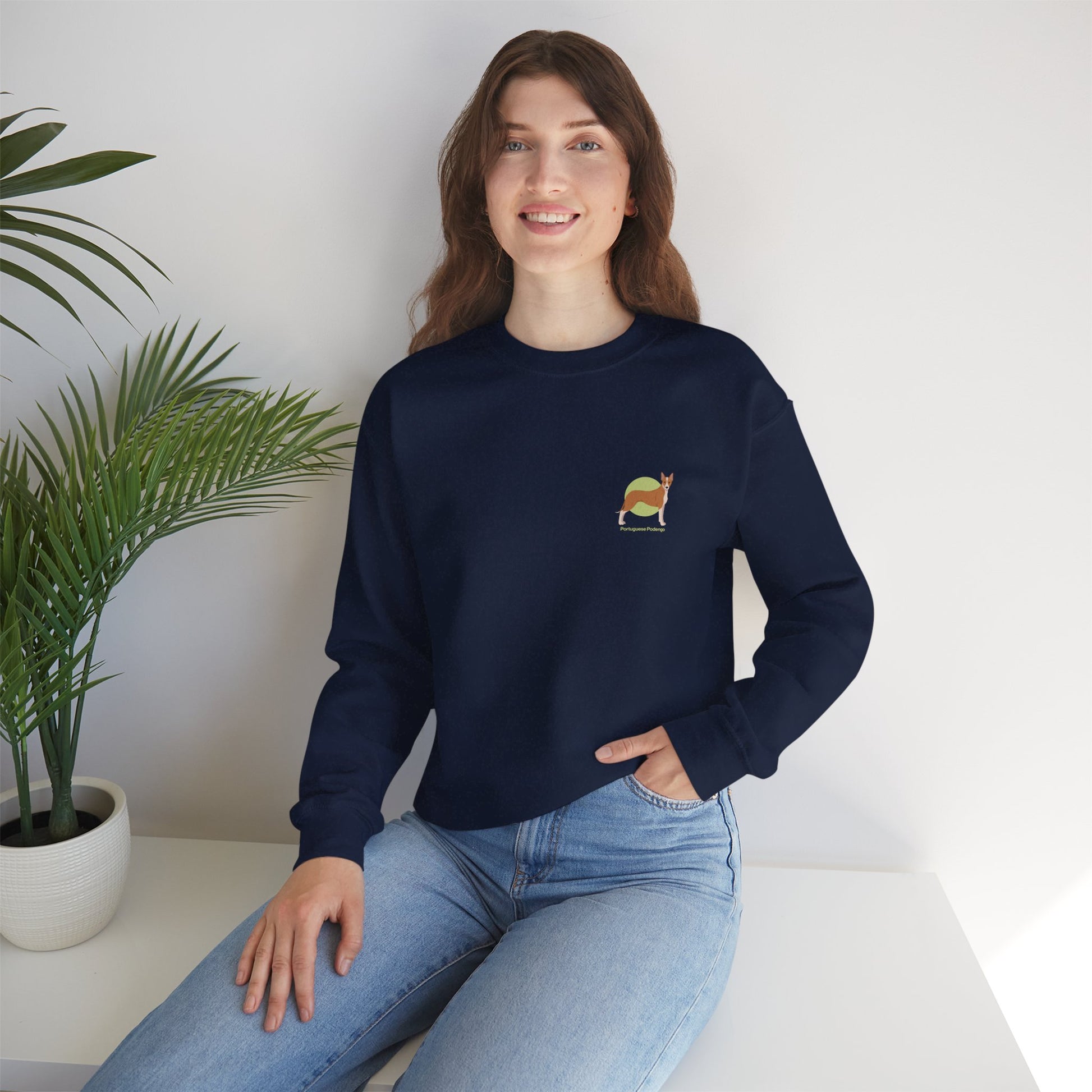 Woman in Portuguese Podengo dog crewneck sweatshirt, navy blue, sitting indoors with plant in background