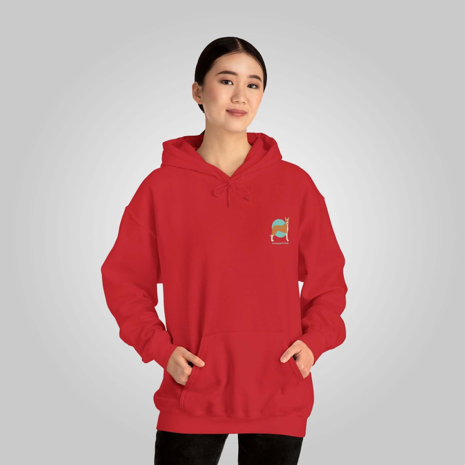 Woman wearing a red Portuguese Podengo dog hoodie, showcasing a small logo with a colorful dog design on the chest.