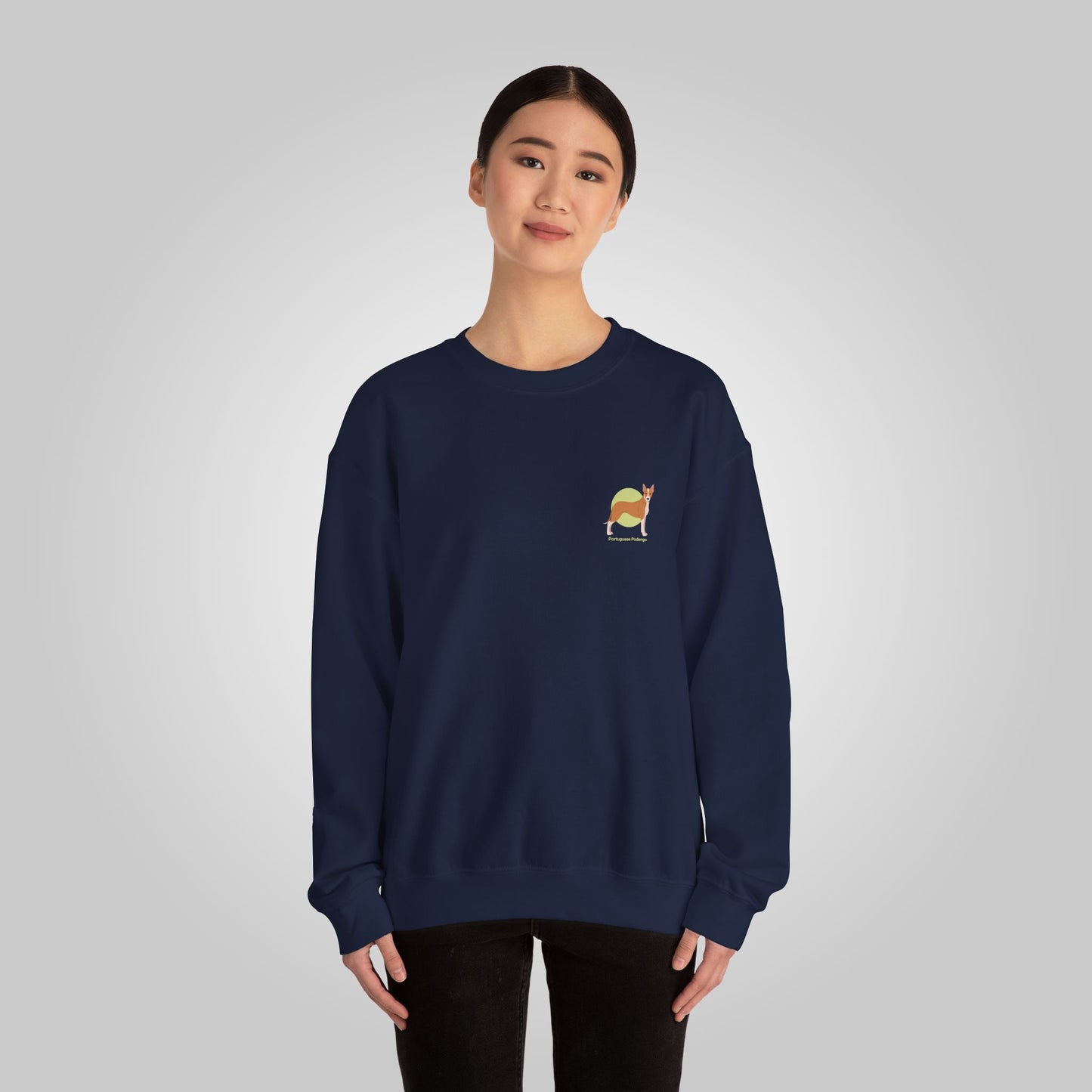 Woman wearing a navy blue Portuguese Podengo unisex crewneck sweatshirt with a small embroidered dog design on the chest.